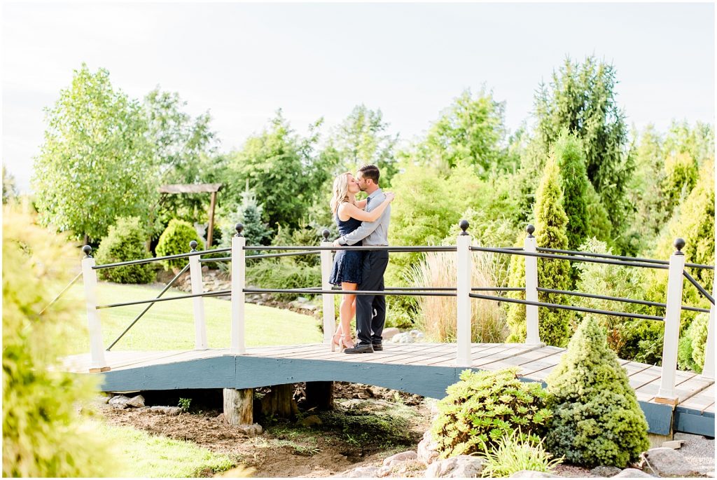 whistling gardens engagement session fiance couple kissing on bridge