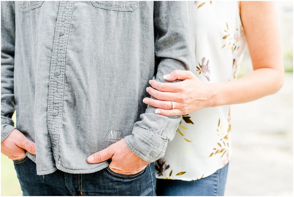 whistling gardens engagement session fiance couple snuggling ring detail