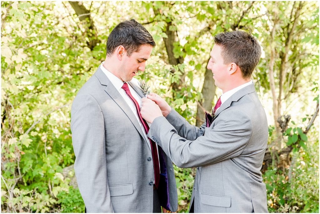 St. Mary's Countryside Wedding groomsmen putting on corsages