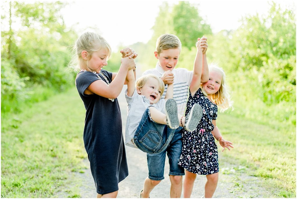 waterford trails family session kids running while swinging their little brother