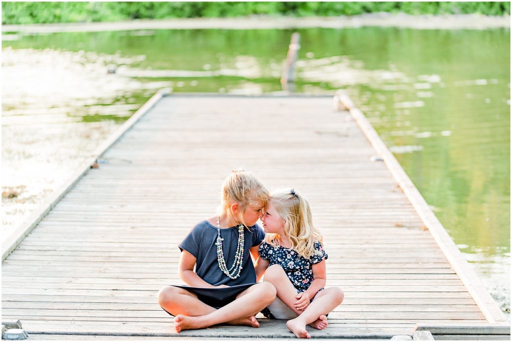 waterford ponds family session sisters sitting on dock