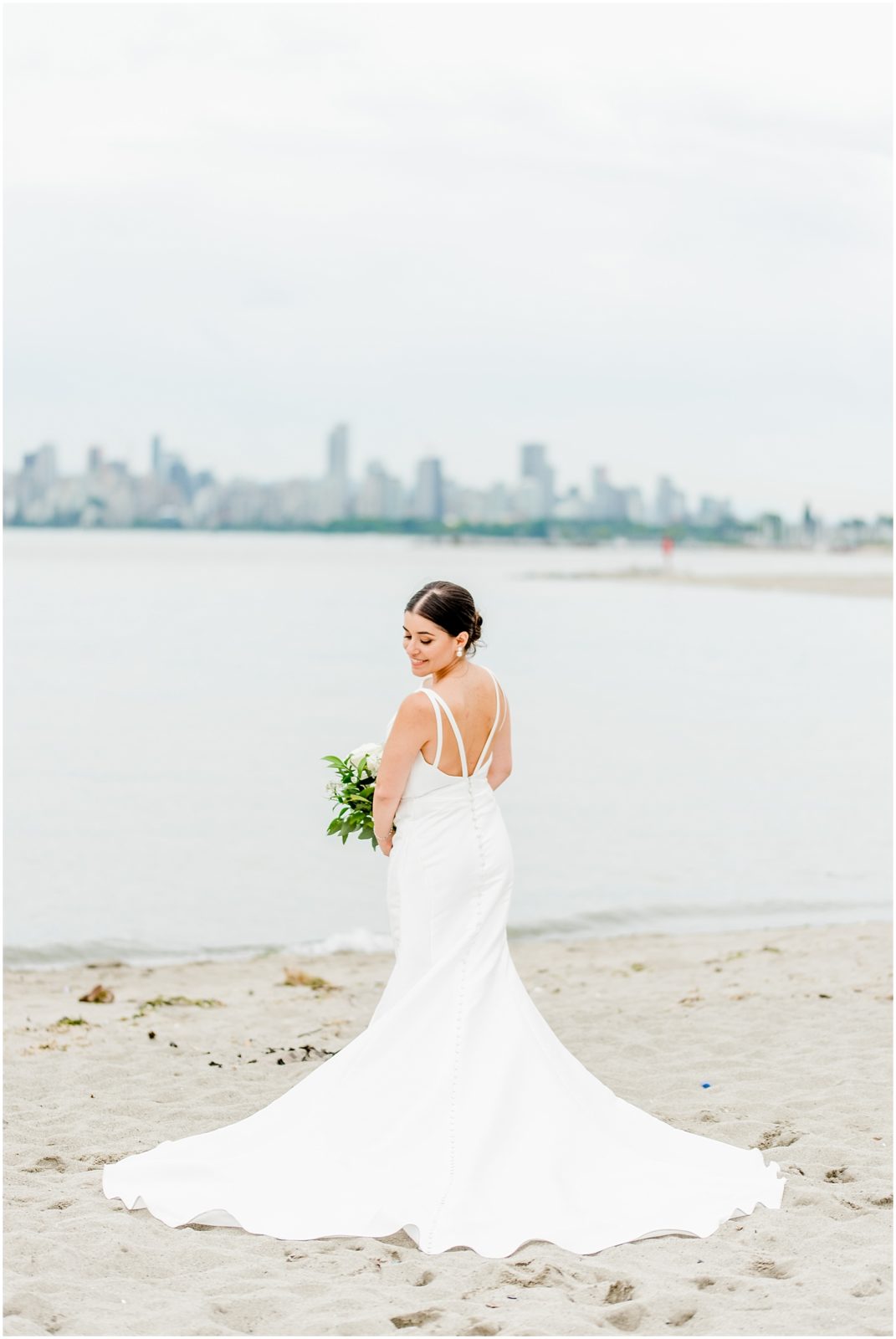 Burnaby Vancouver Wedding Bride standing on the beach at Spanish Banks, back of the dress visible