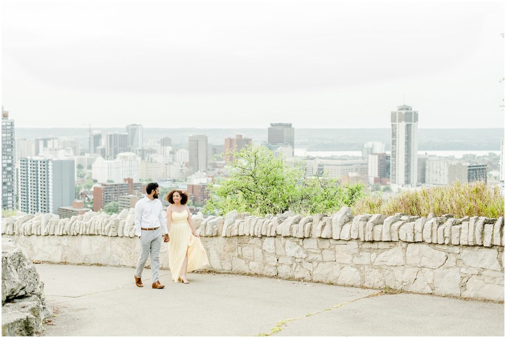 Sam Lawrence Park Hamilton Engagement Session couple walking on pathway with perfect view of the city