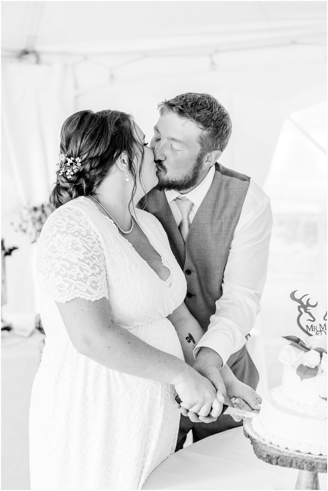 Princeton backyard wedding bride and groom kissing while cutting the cake