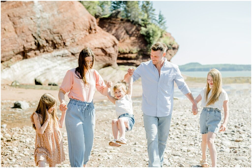 Saint Martins Portrait Session family holding hands swinging toddler