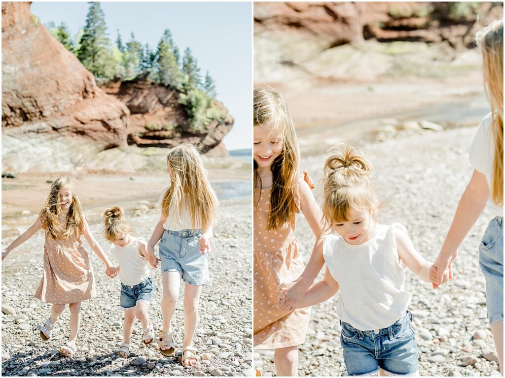 kids holding hands laughing walking on the shore