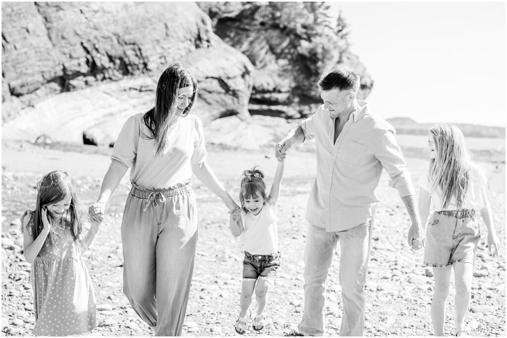 Saint Martins Portrait Session black and white photo of family holding hands on the shore