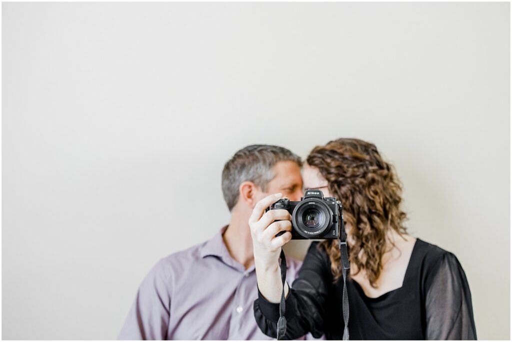 Christian Photography Business Photographers kissing behind Nikon mirrorless camera