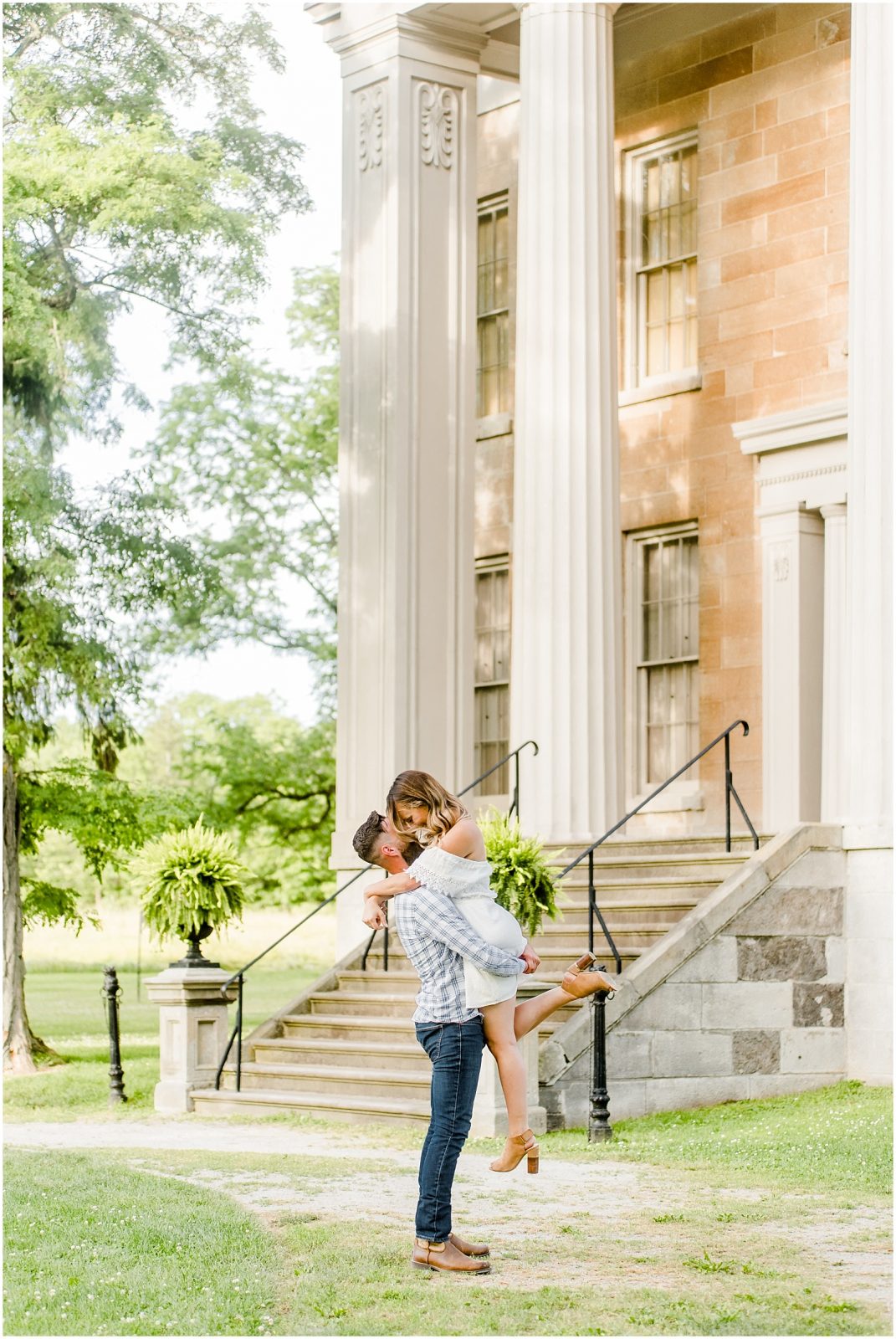 Couple kissing in front of steps at Ruthven Park
