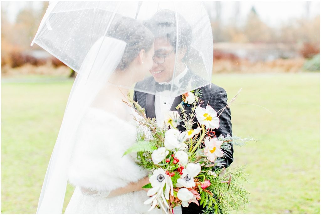 burnaby vancouver wedding bride and groom under umbrella at Trout Lake