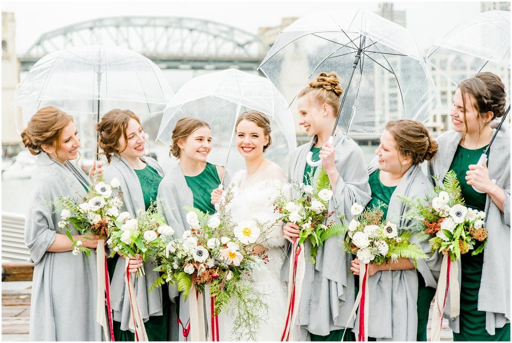 burnaby vancouver wedding bride and bridesmaids laughing holding umbrellas at Granville Island